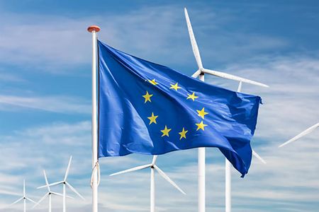 EU-Flagge vor einem gro&szlig;en Windpark mit Windr&auml;dern