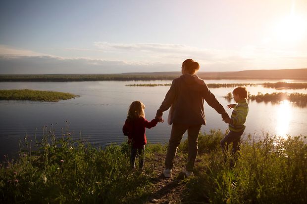 Mom,And,Two,Kids,Walk,Near,The,River.,Social,Distancing.