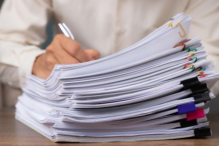 Male,Office,Workers,Holding,And,Writing,Documents,On,Office,Desk,