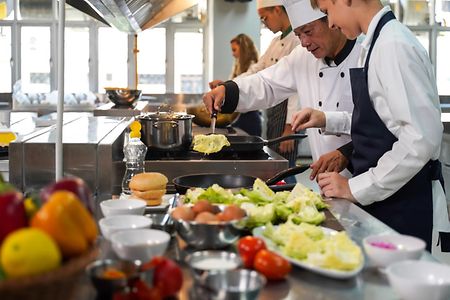 Chef preparing student for learning marking and cooking food at workshop.