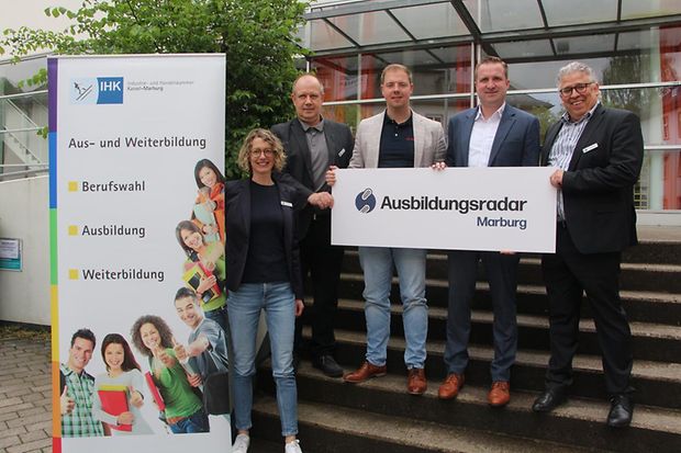 Personen stehen auf Treppe und halten Schild Ausbildungsradar