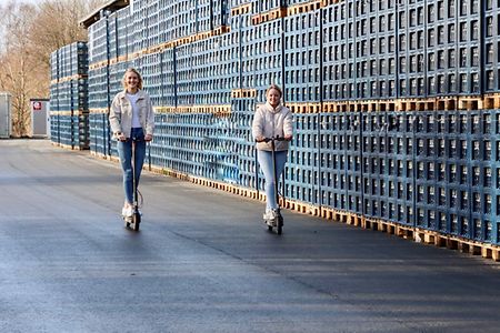 Werkstudentin Talisa und Jana, Aushilfe Marketing, auf E-Scootern