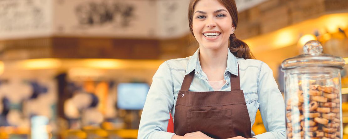 Attractive baker in uniform at the counter