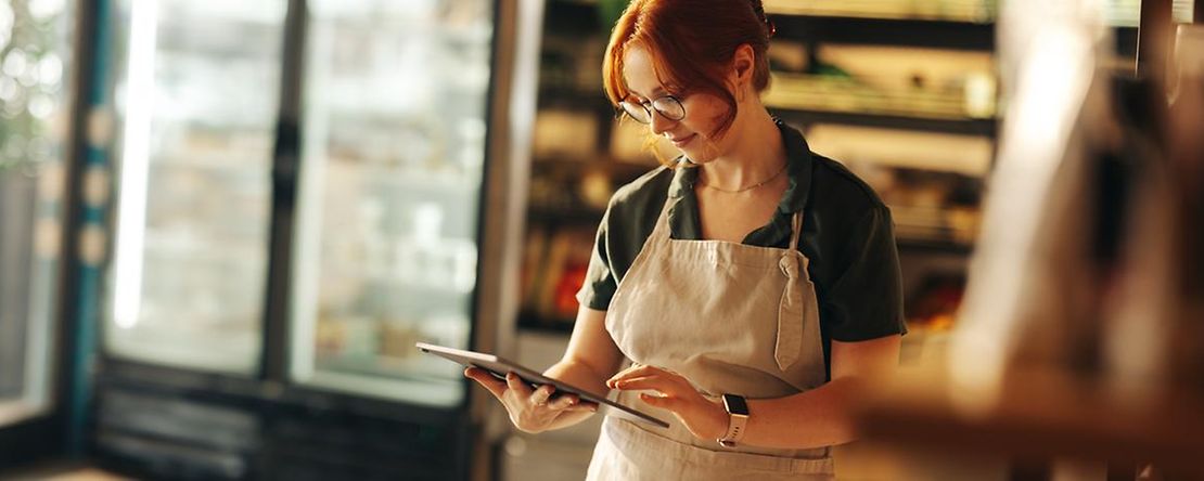Happy,Supermarket,Owner,Using,A,Digital,Tablet,While,Standing,In