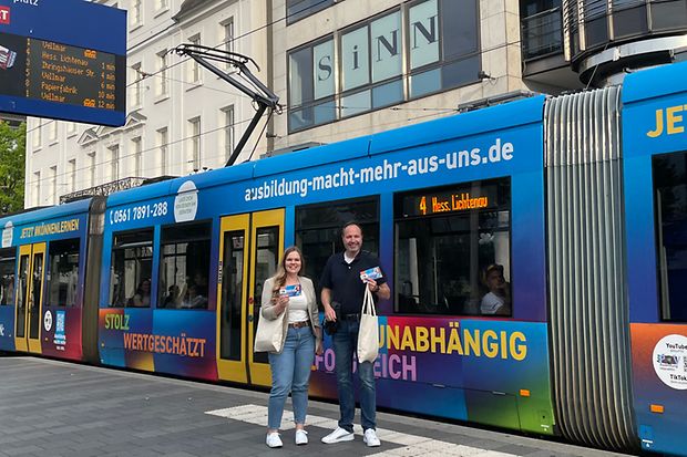 Sophie Thiele und Dr. Thomas F&ouml;lsch stehen vor Stra&szlig;enbahn und verteilen Beratungsgutscheine