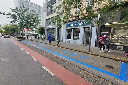 Wirtschaftszone auf der Venloer Stra&szlig;e in K&ouml;ln; gekennzeichnet durch blaue Markierungen und Piktogramme auf dem Boden.