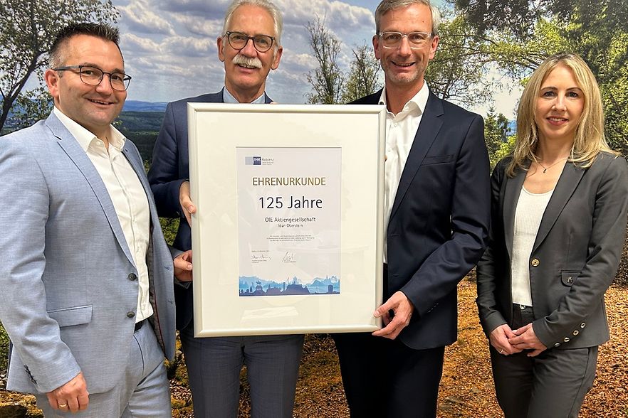 4 Personen mit gerahmter Urkunde