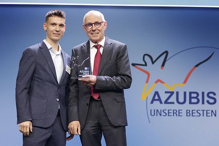 Mann &uuml;berreicht Pokal