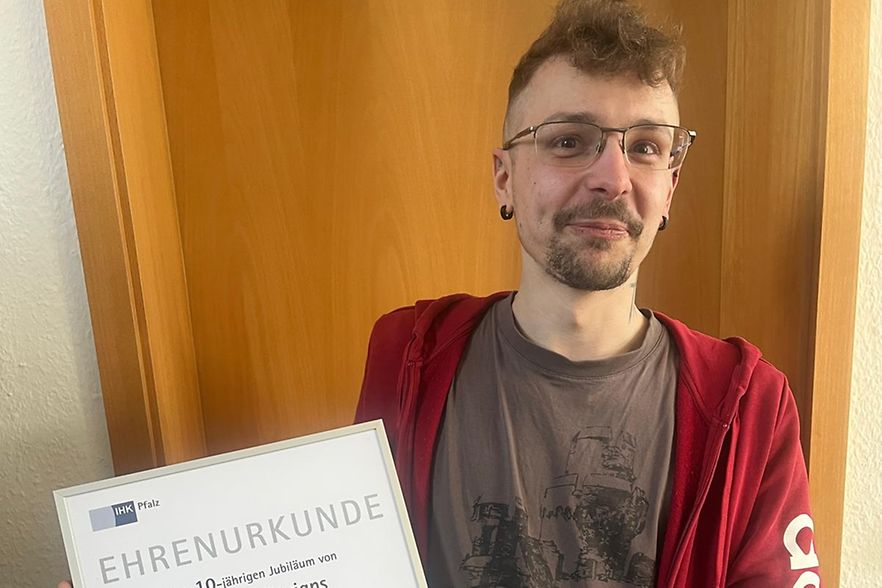 Pascal Schmidt mit seiner Urkunde f&uuml;r das 10-j&auml;hrige Jubil&auml;um.