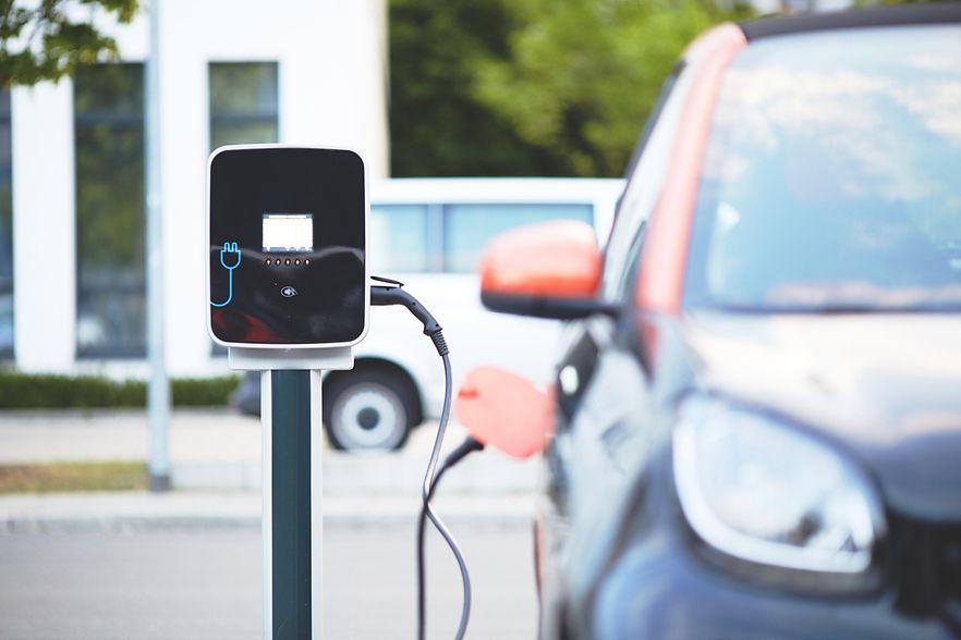 E-Lades&auml;ule mit Auto daneben
