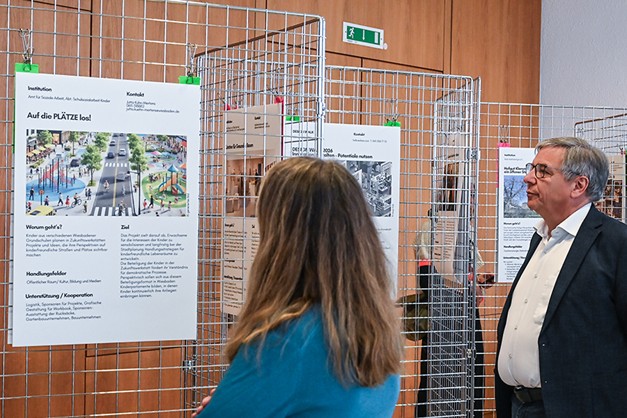Eine Frau und ein Mann betrachten Plakate.