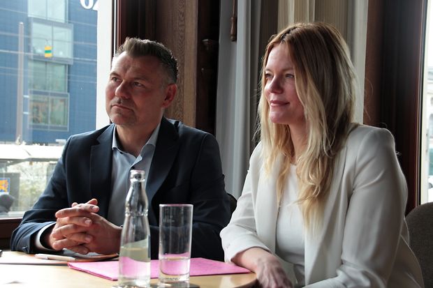 Ein Mann und eine Frau sitzen an einem Tisch in einer Interview-Situation