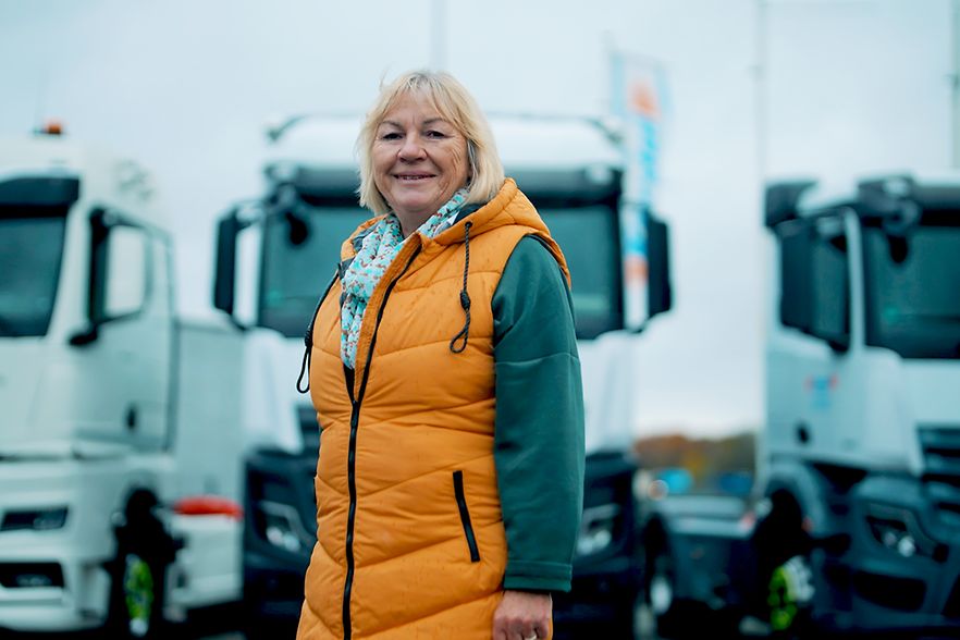 Unternehmerin Ellen K&ouml;rdel-Heinemann vor LKWs ihres Fuhrparks