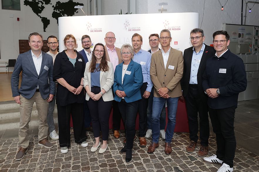 Gruppenfoto der ReTraSON-Partner: 12 M&auml;nner und Frauen vor einer Pressewand .