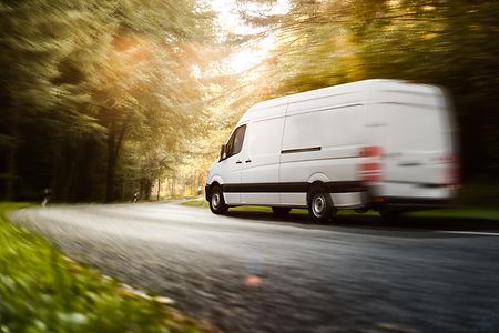 Kleintransporter f&auml;hrt z&uuml;gig &uuml;ber eine Landstra&szlig;e