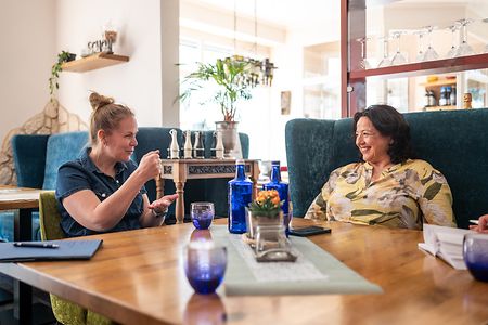 Natasha Stolte und Anna-Rita Fanelli weiter sitzen gemeinsam am Tisch und unterhalten sich.