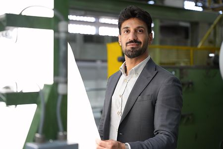 Portr&auml;t Amir Mirsakarimi in der Produktionshalle. Er h&auml;lt ein wei&szlig;es Papier in den H&auml;nden.