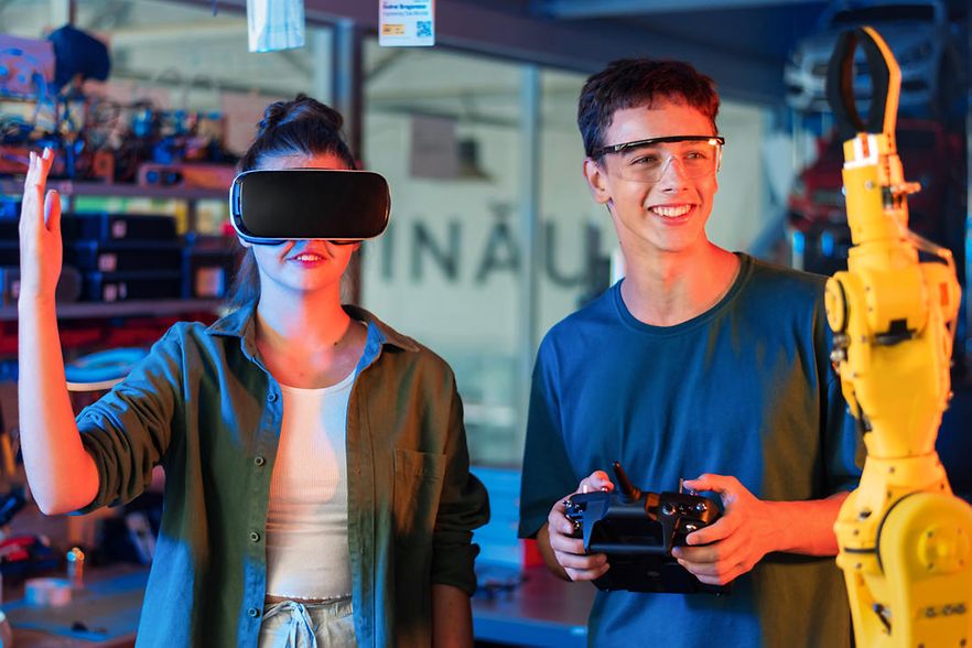 Teens remotely controlling robots in a laboratory