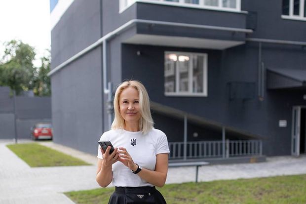 Eine Frau h&auml;lt ein Handy in der Hand