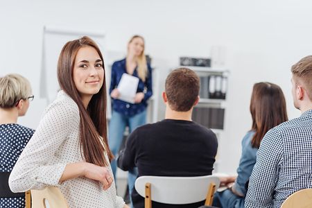 Young woman in a lecture turning to camera