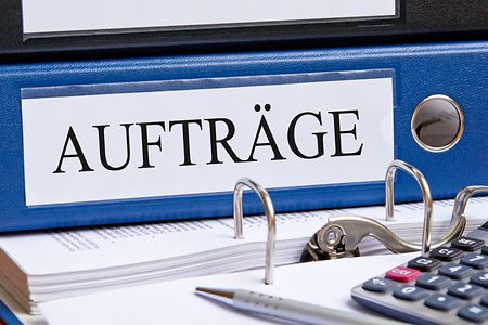 Blauer Ordnerr&uuml;cken mit der Aufschrift Auftr&auml;ge
