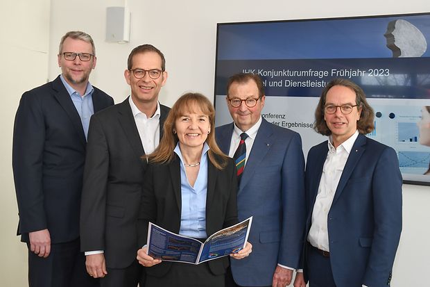F&uuml;nf Personen stehen vor einem Bildschirm zur IHK-Konjunkturumfrage.