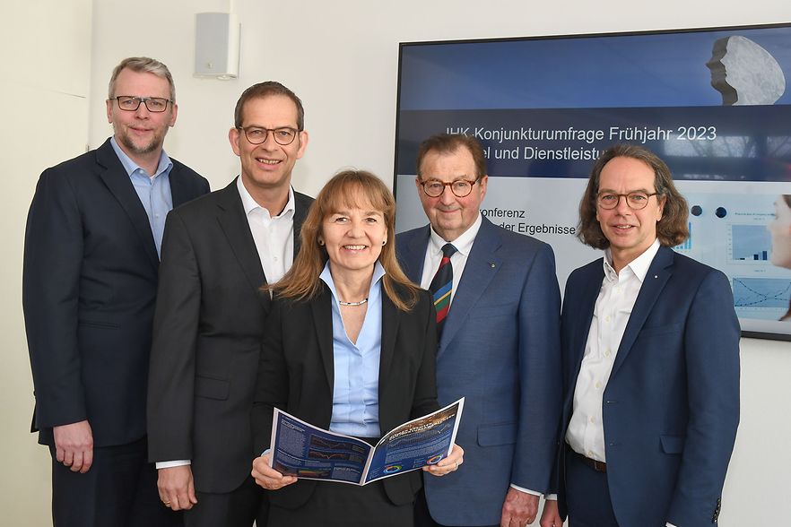 F&uuml;nf Personen stehen vor einem Bildschirm zur IHK-Konjunkturumfrage.