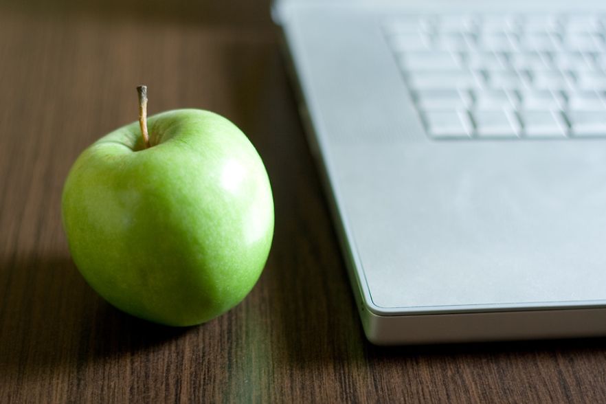 Gr&uuml;ner Apfel neben einer Laptop-Tastatur