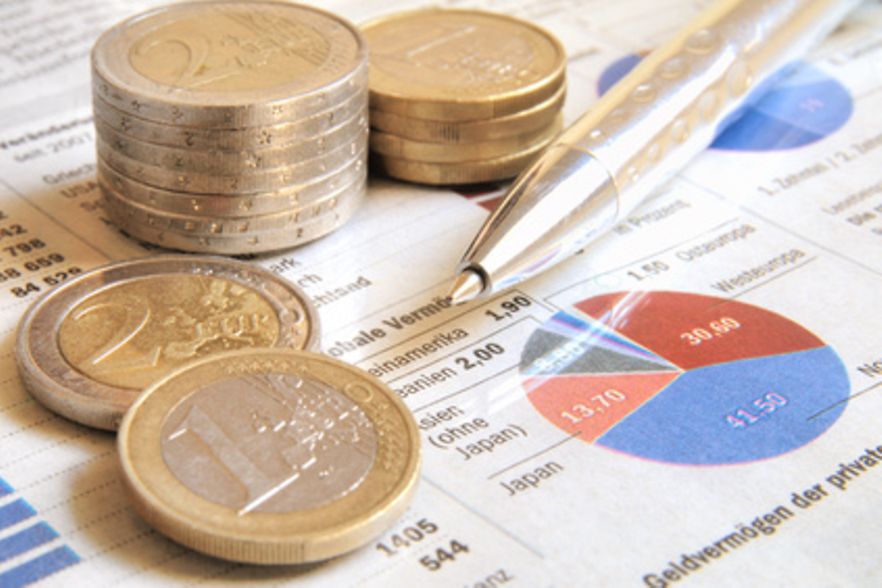 Euro-M&uuml;nzen und Stift auf Diagramm