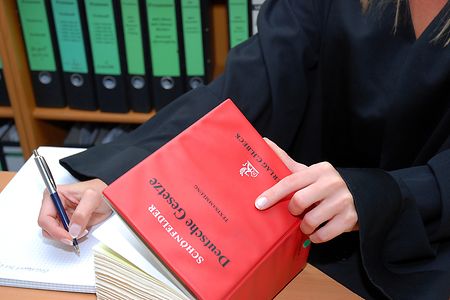 Anw&auml;ltin mit Gesetzbuch beim Schreiben