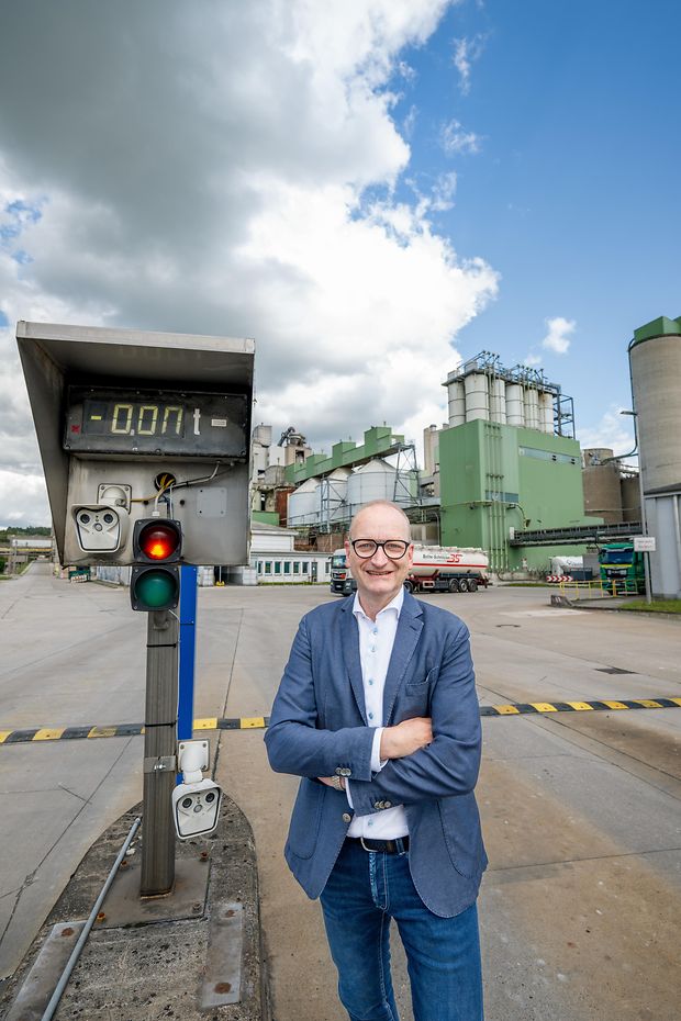 Dr. Martin Oerter steht draußen vor dem Zementwerk mit verschränkten Armen