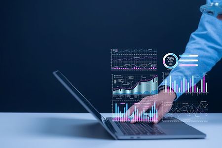 Person arbeitet am Laptop mit virtuellen Daten- und Diagrammprojektionen.