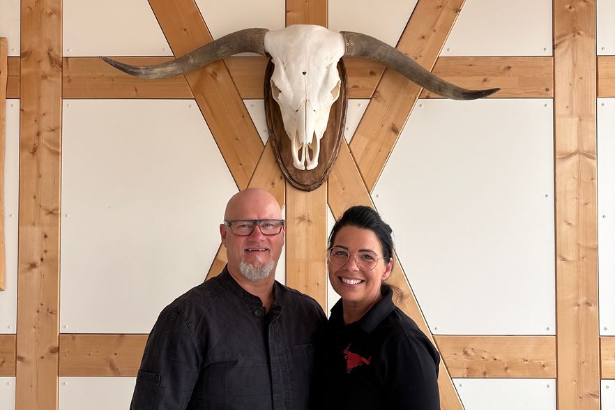 Andreas W&ouml;lfer und Mandy W&ouml;lfer von Fleischwerk VIII vor einem Rinderkopf an der Wand