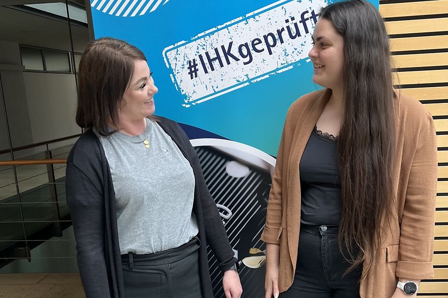Die Fachberaterin steht mit der Pr&uuml;ferin vor einem IHK-Roll-up