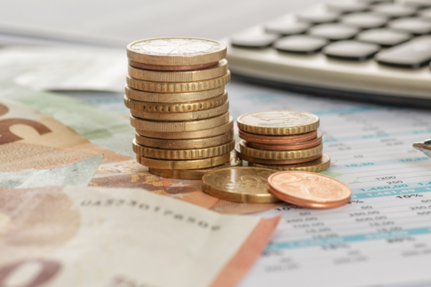 Geld mit Taschenrechner und Kugelschreiber