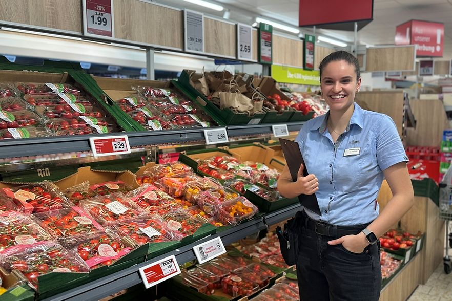 Frau steht im Supermarkt vor Gem&uuml;setheke