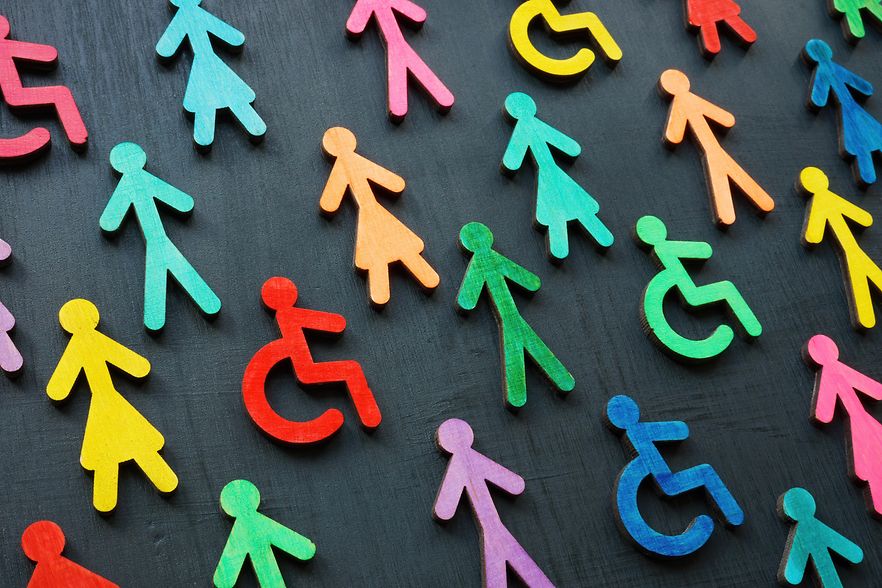 Bunte Figuren mit und ohne Behinderung auf dunklem Hintergrund