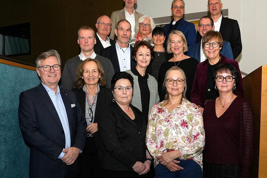 Gruppenfoto mehrerer Personen bei einer Veranstaltung auf einer Treppe.