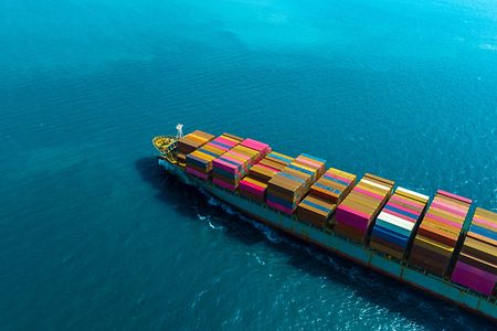 Ein Containerschiff f&auml;hrt &uuml;bers Meer.