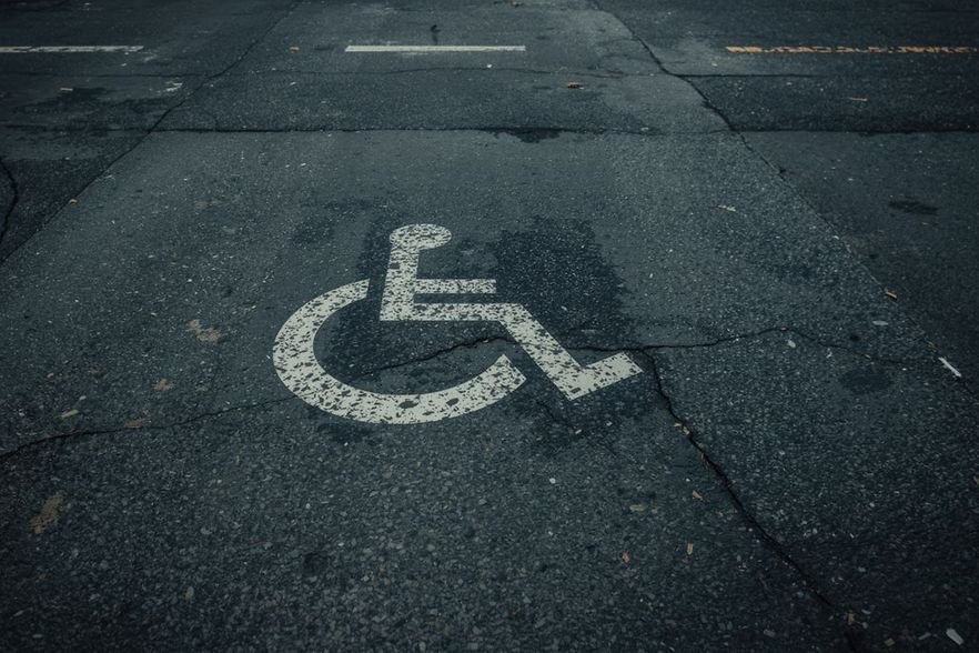 Rollstuhlsymbol auf rissigem Asphalt