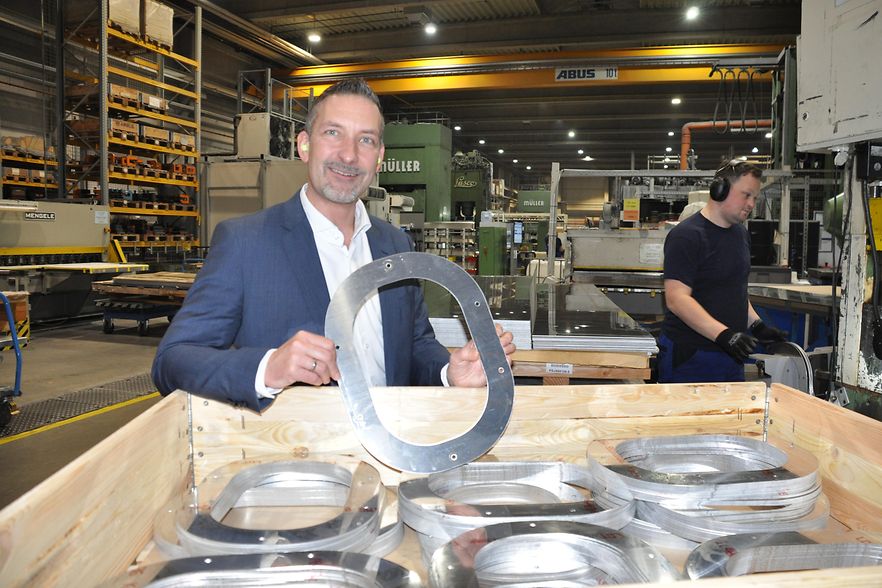 Mann mit rundem Metallst&uuml;ck in der Hand
