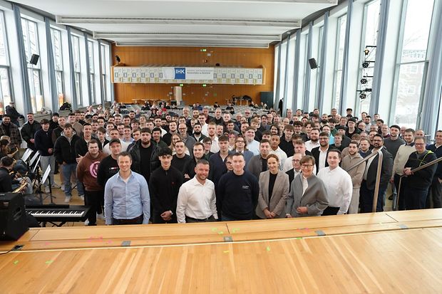 Gruppenfoto von zahlreichen Teilnehmenden in einem gro&szlig;en, hellen Saal.