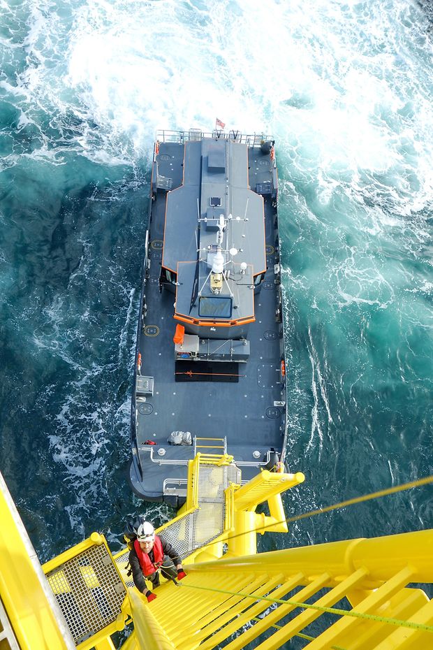 Ein Arbeiter klettert eine Leiter an einer Offshore-Anlage hoch