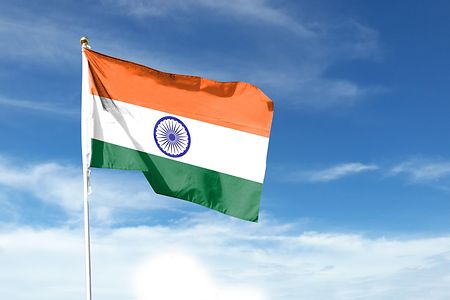 Die indische Flagge vor blauem Hintergrund