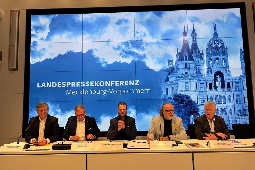 F&uuml;nf Herren im Anzug sitzen auf einem Podium. Hinter ihnen an der Wand steht "Landespressekonferenz".