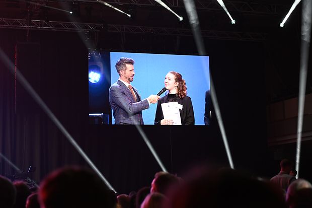 Ella R&uuml;ckerl im Interview auf einem gro&szlig;en Bildschirm bei der nationalen Bestenehrung der DIHK