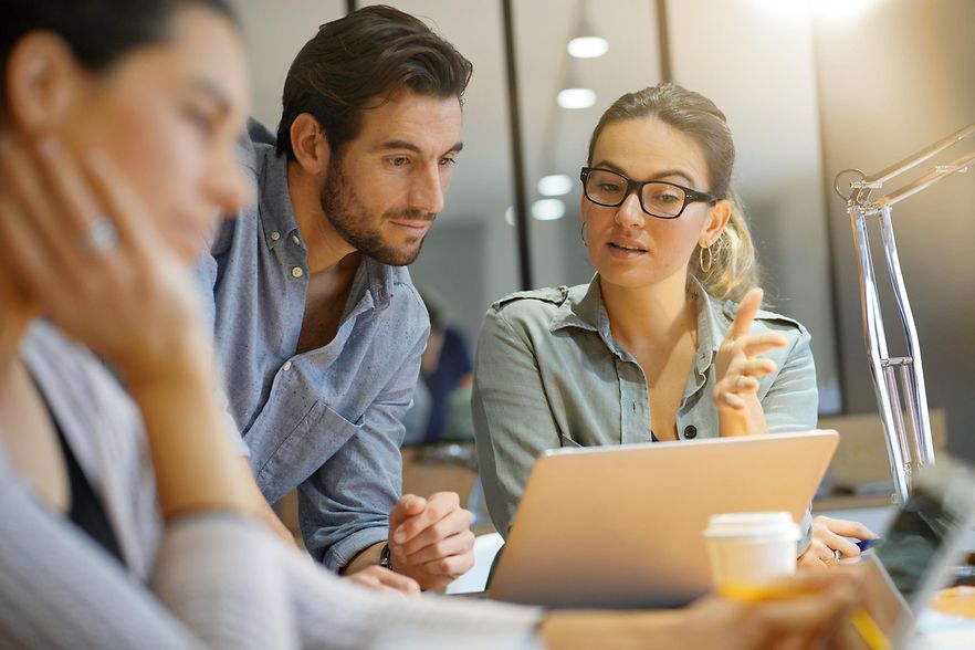 Drei Menschen im B&uuml;ro besprechen etwas