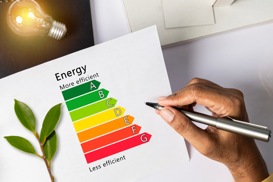 Schreibtisch mit einem Zettel, auf dem "Energie" steht, mit Energieampfel