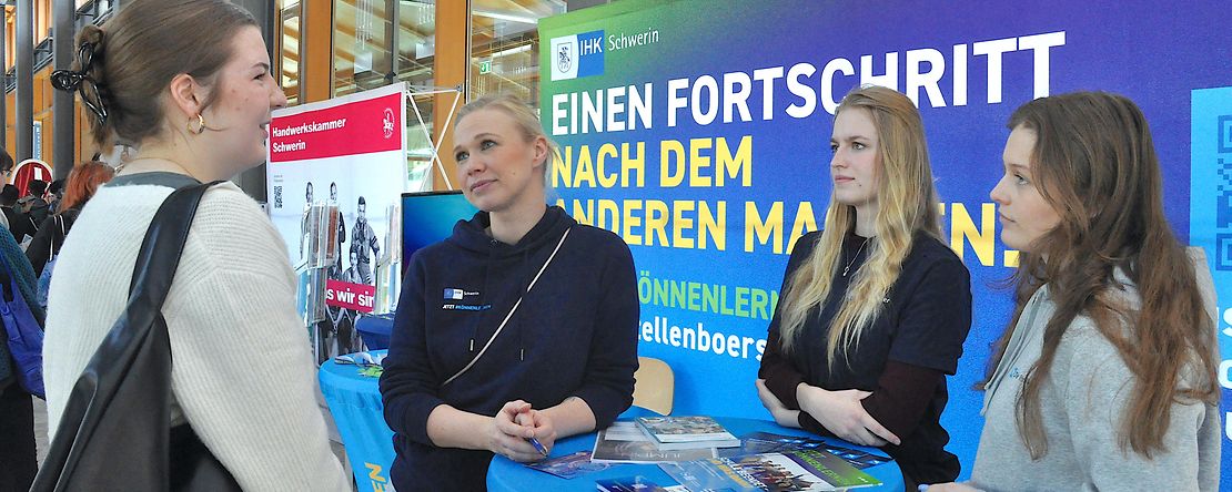 Stand auf einer Berufsmesse mit Beratungssituation