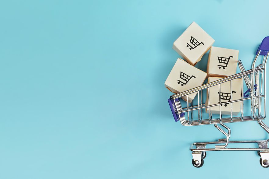 Boxes in a shopping cart on blue background. Concept: online shopping, e commerce and delivery of goods. Copy space.